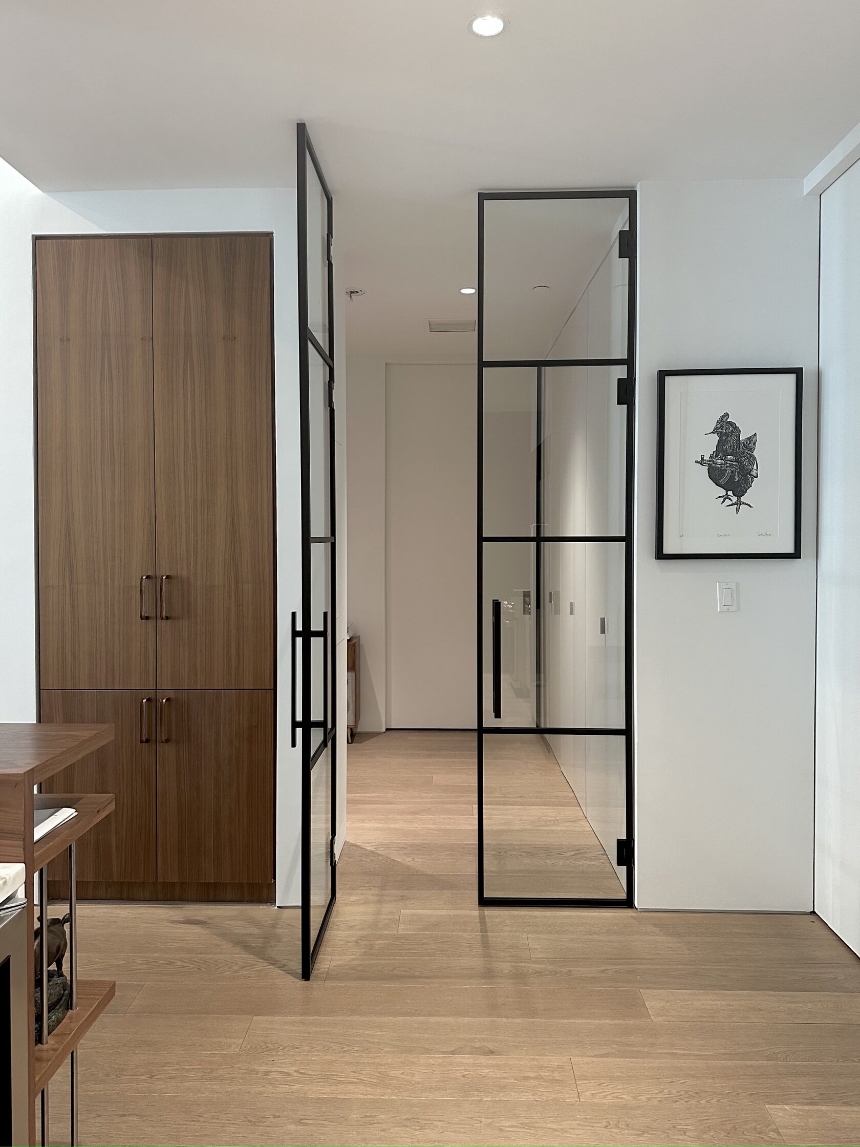 Custom glass partition separating a kitchen from a dining room