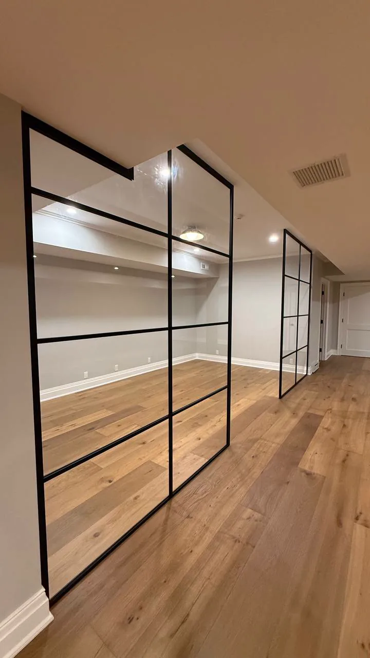 Close view of a glass partition frame notched around a ceiling soffit, Connecticut by WiseGlass NY