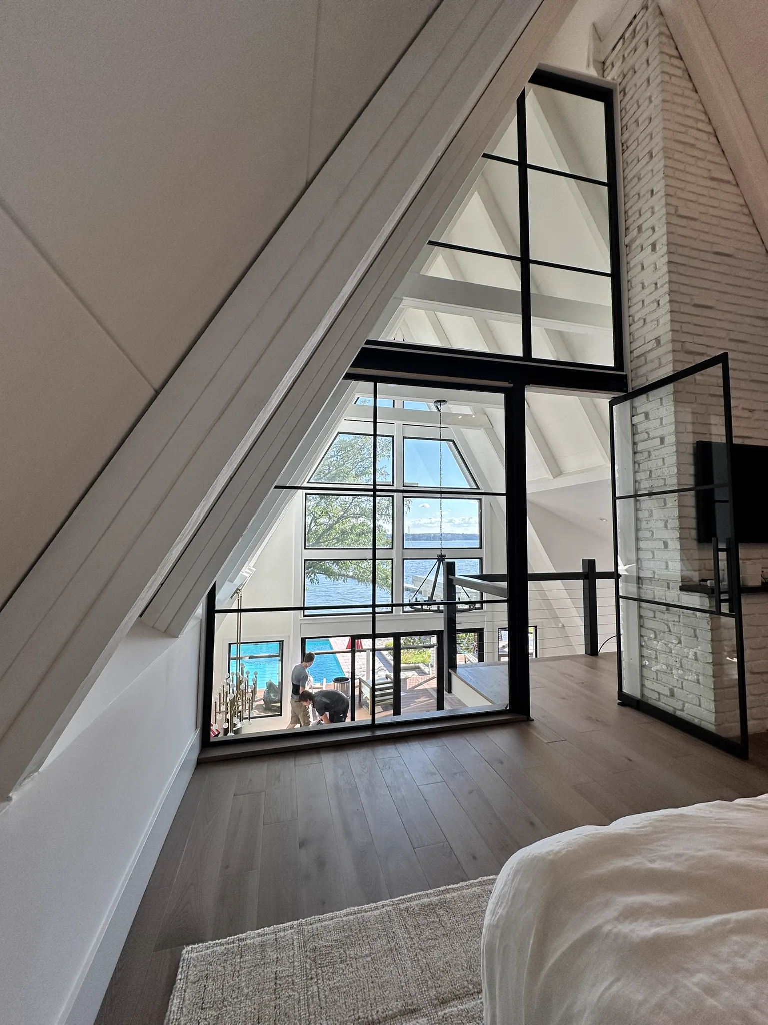 View from attic bedroom through complex floor-to-ceiling black matte glass partition — waterfront beach house by WiseGlass NY