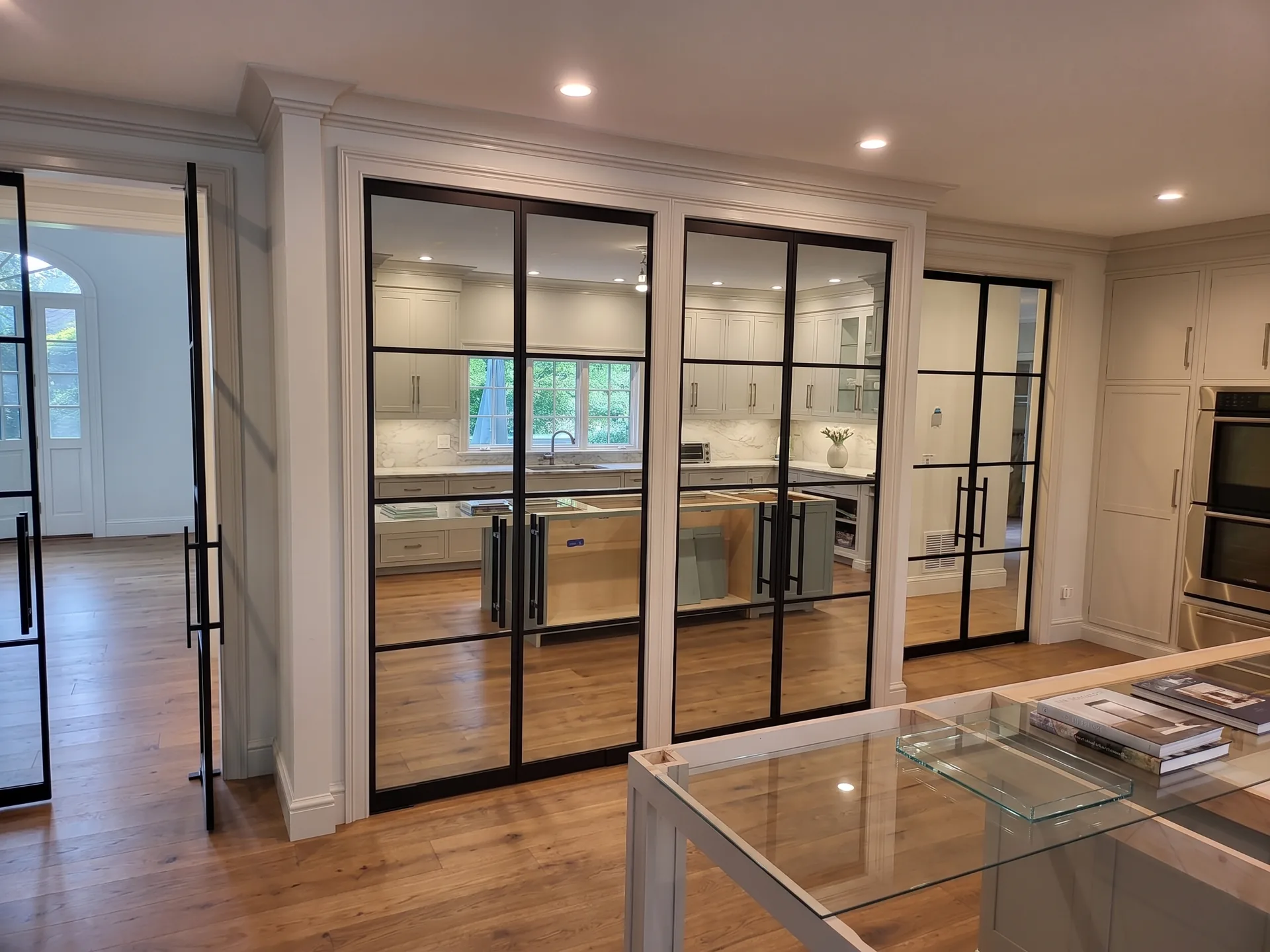 Custom black matte French doors with grid design separating kitchen from living area — WiseGlass NY