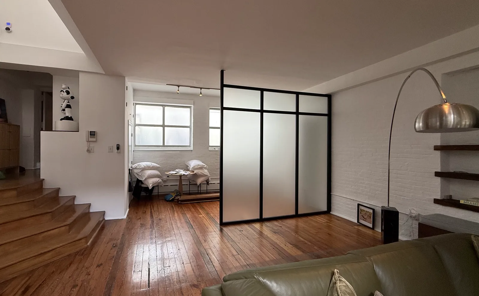Frosted glass partition on structural frames enclosing a sleeping area in a painted brick Manhattan loft, by WiseGlass NY