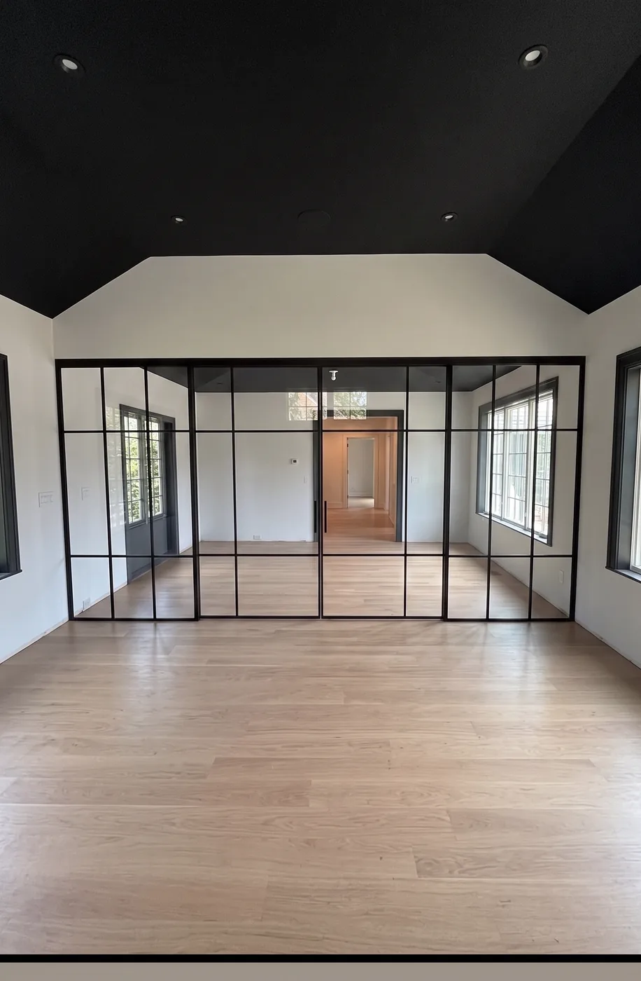 Custom grid glass partition beneath a dark green vaulted gable ceiling, upstate New York by WiseGlass NY