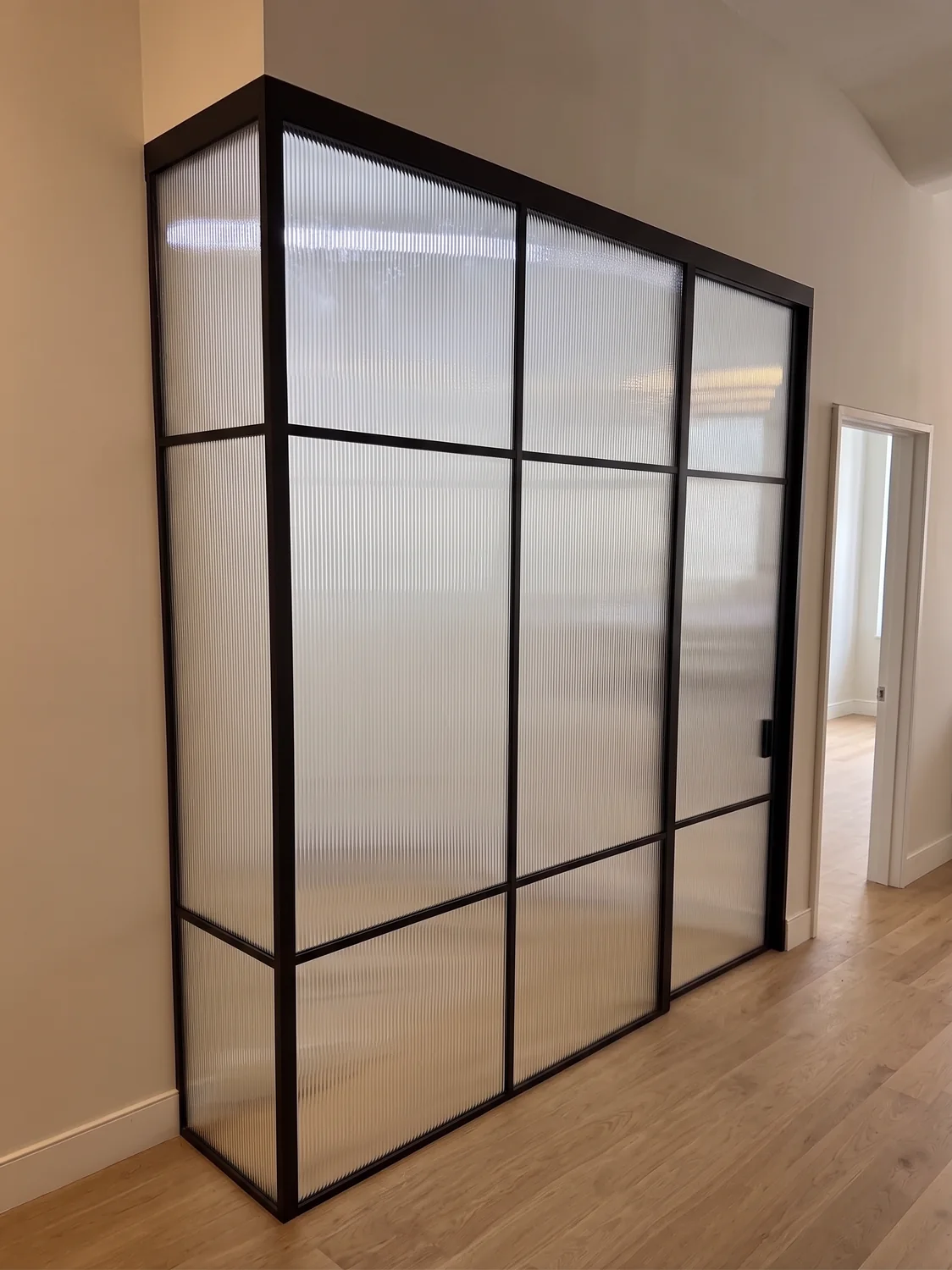 L-shaped reeded glass partition in a black matte frame, Manhattan apartment by WiseGlass NY