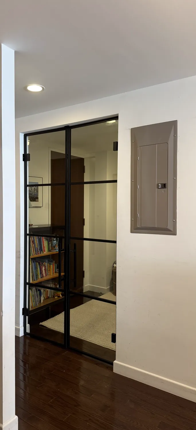 Tinted French glass doors on butt hinges with weatherstrips closing off a library, New York City by WiseGlass NY