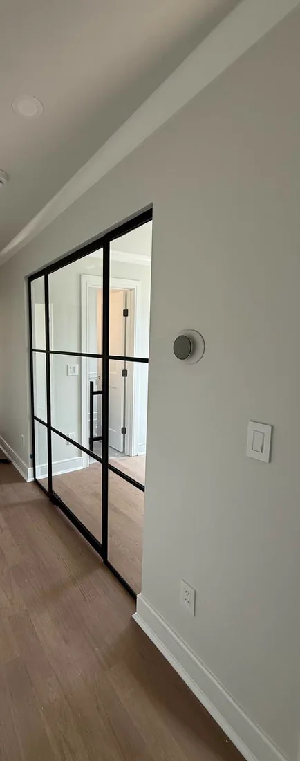 Glass swing door with sidelights seen down a hallway, New Jersey home by WiseGlass NY
