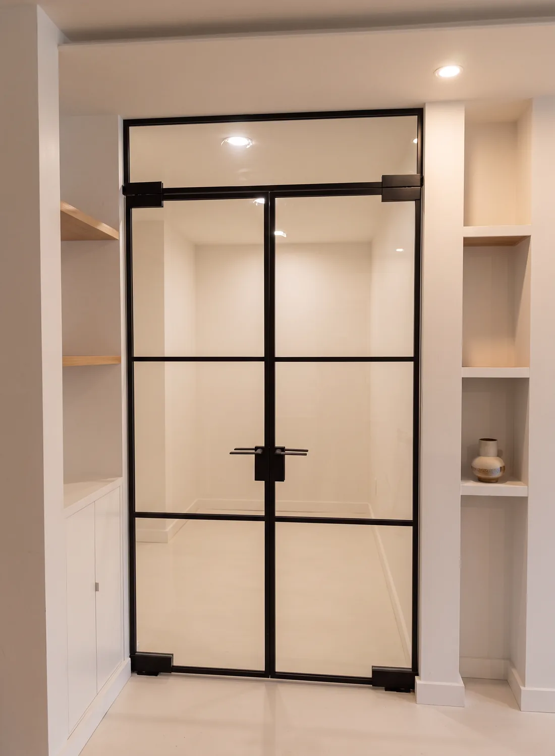 Transom French glass doors set between two runs of built-in shelving, Manhattan by WiseGlass NY